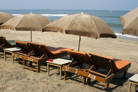 Plank beds and sunshades on a beach. India Goa