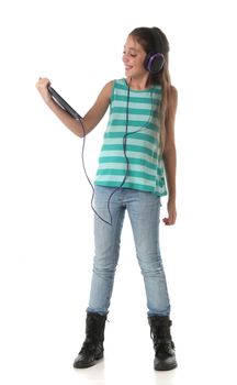 Beautiful pre-teen girl using a tablet computer and headphones. Isolated