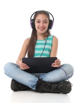 Beautiful pre-teen girl using a tablet computer and headphones