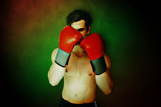 Composite image of muscly man wearing red boxing gloves in guard position