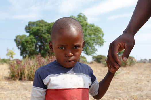 Portrait of Namibian small boy with fathers hand