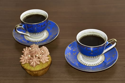 Coffee Cups and Cupcake on Wooden Table