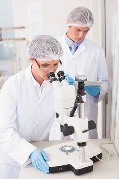 Scientists working attentively with microscope 