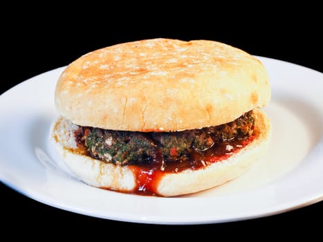 Closeup of juicy hamburger between buns with delicious red sauce
