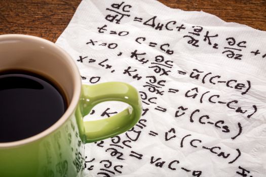 mathematical equations of physics - handwriting on a napkin with a cup of coffee