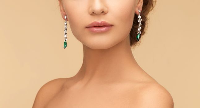 woman with diamond and emerald earrings