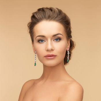 woman with diamond and emerald earrings