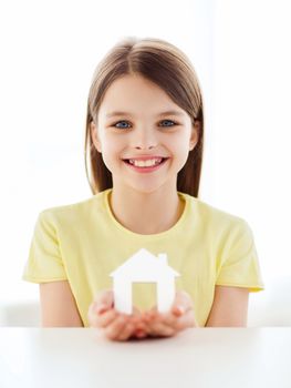 home and family concept - little girl holding white paper house