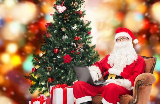 man in costume of santa claus with laptop