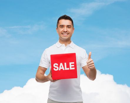 smiling man with red sale sigh showing thumbs up
