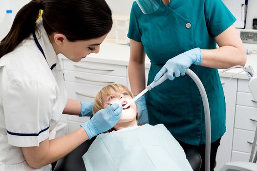 Female dentist treat child patient