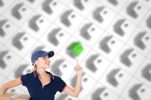 Composite image of happy delivery woman holding cardboard box and pointing up