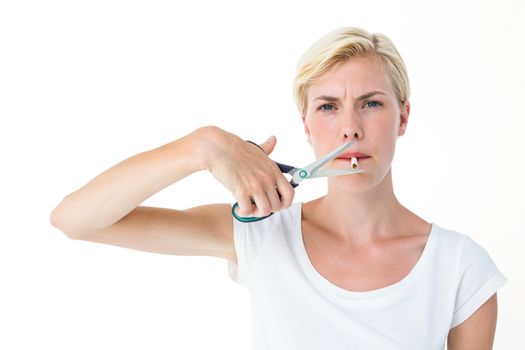 Attractive blonde woman cutting cigarette with scissors