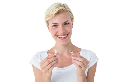Attractive blonde woman snapping cigarette and smiling at camera