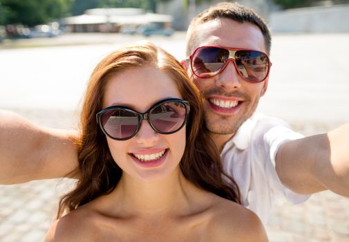smiling couple wearing sunglasses making selfie