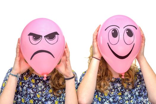Two girls holding pink balloons with facial expressions