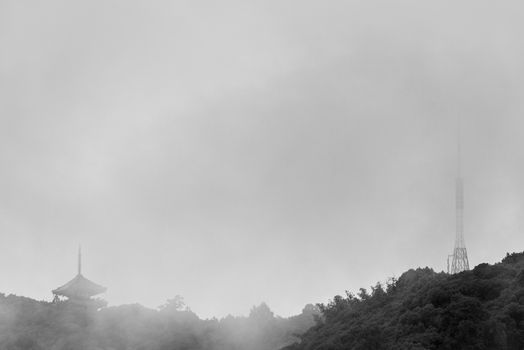 Japanese Pagoda and Radio Tower on Foggy Mountain