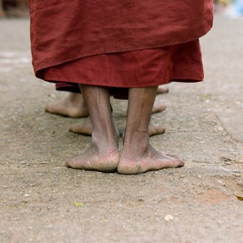 Foots of ascetic Buddhist monk walking at the way to  Kyaikhtiyo