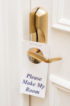Sign hangs on a door handle.