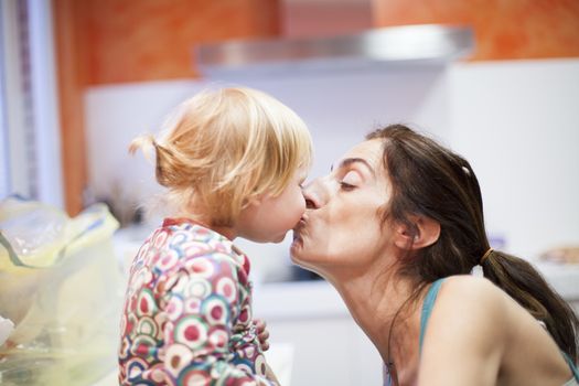 baby and mom kissing in kitchen