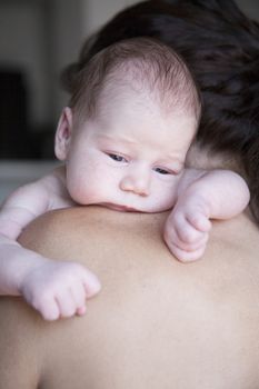 face newborn baby on mother shoulder