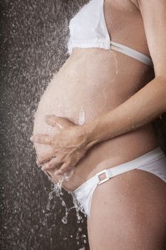 hands on tummy pregnant under shower