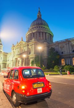 LONDON - JUNE 12, 2015: Red cab under Saint Paul Cathedral at ni