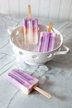 Frozen yogurt popsicles on marble counter