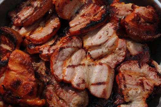 Barbecuing meat on charcoal fire closeup image.