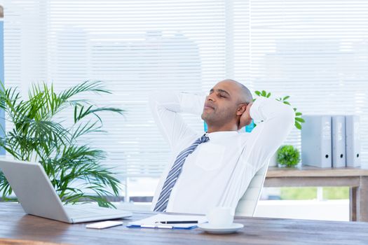 Relaxed businessman lying down in swivel chair