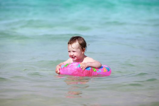 Little girl with rubber ring in the sea