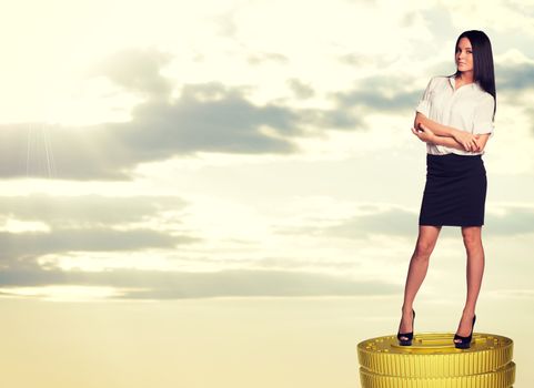 Seriuos businesswoman standing on coins stack