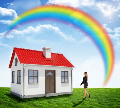 Businesswoman going to house with rainbow