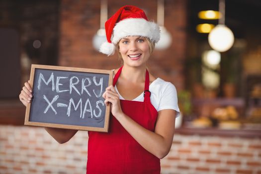 Pretty waitress with a chalkboard merry x-mas