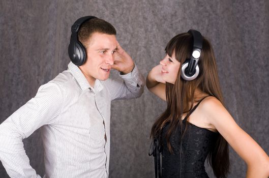 Happy smiling man and woman with headphones listening to music together