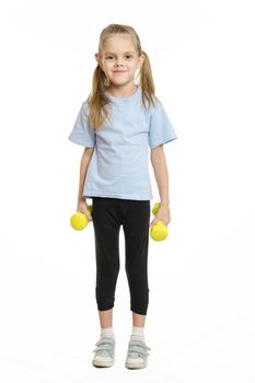 Six year old girl athlete standing with dumbbells