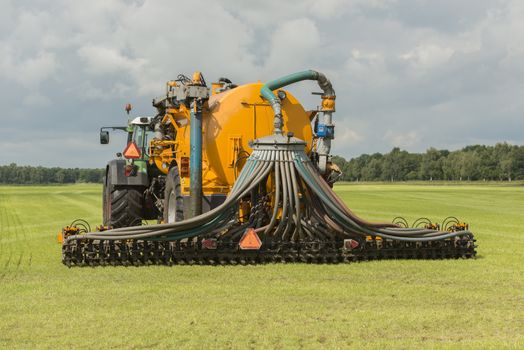 Injecting of liquid manure with tractor and yellow vulture sprea