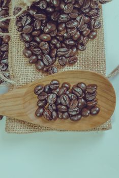 Coffee beans and wooden spoon on sack surface.Filter effect retr
