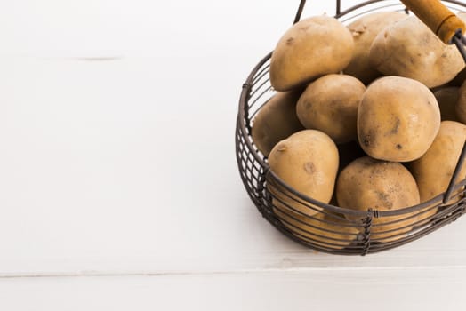 uncooked potatoes in wire basket