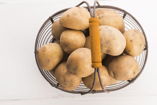 uncooked potatoes in wire basket