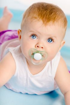 Beautiful baby with a pacifier. Close-up. Studio photo