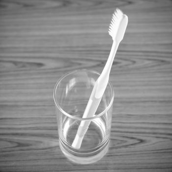toothbrush in glass on wood background black and white color tone style