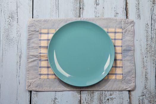 Empty plate on light blue wooden background
