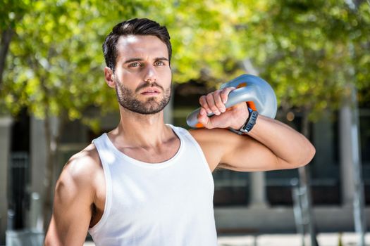 Handsome athlete outfit with a kettlebell