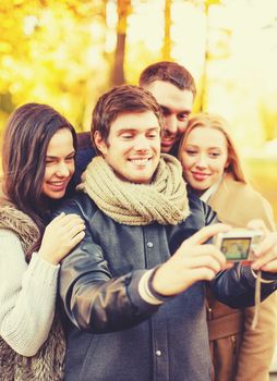 group of friends taking selfie in autumn park