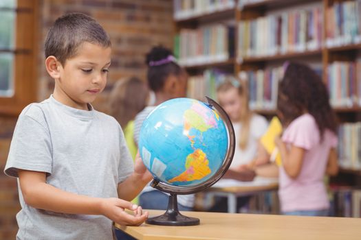 Pupil in library with globe