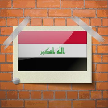 Flags Iraq scotch taped to a red brick wall