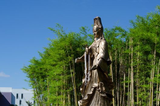 Guan Yin, Goddess of Mercy, with Bamboo Garden in background