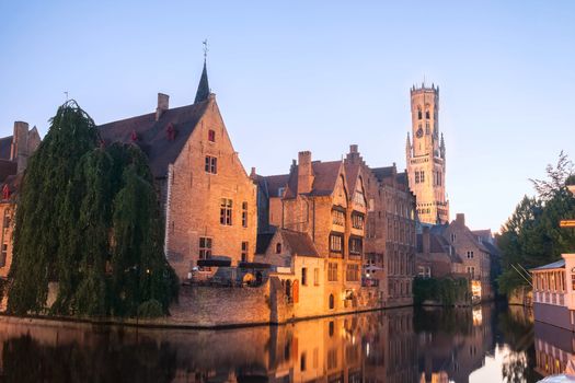 Canal in Bruges with a view on a Belfry at sunset