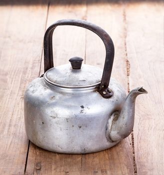 dirty classic aluminum kettle on wooden background